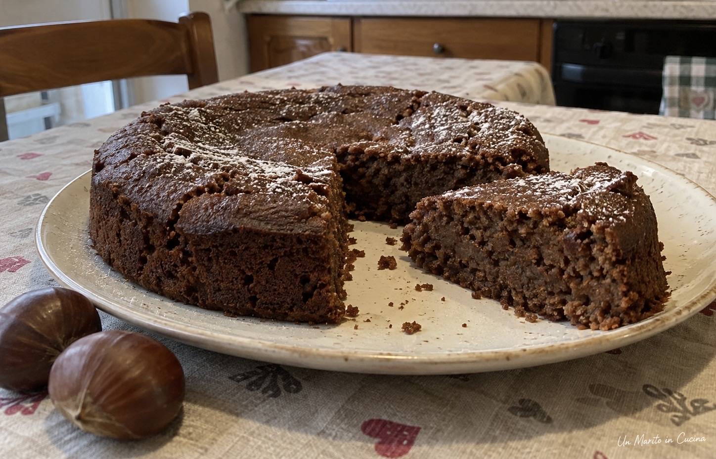 Torta di castagne e cioccolato senza farina, con una fetta tagliata e servita